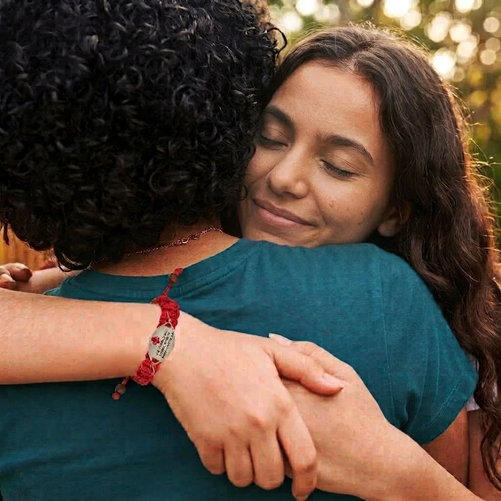 Adolescente con una pulsera SafeID siendo abrazada